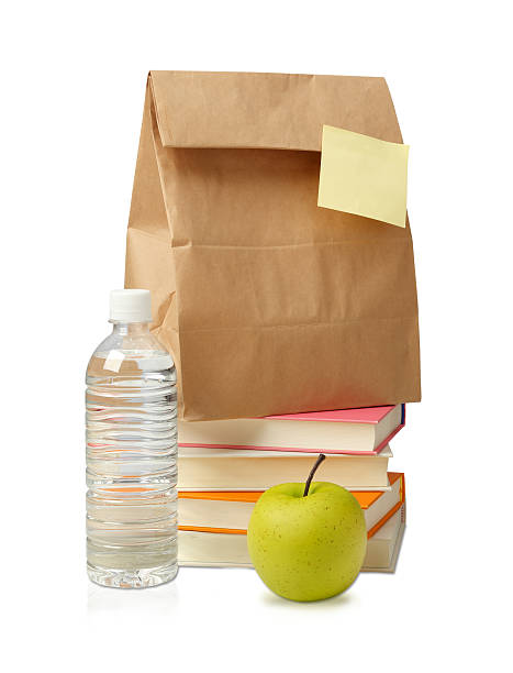 обед мешок с яблоком и водой и книгами. - bag lunch paper bag water bottle стоковые фото и изображения