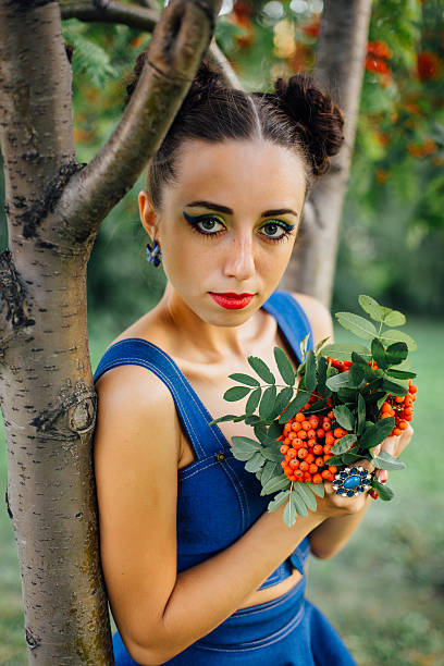 istock Beautiful young woman with rowan berries 613054754