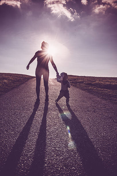 istock Baby walking with help of its parents - first steps 613055378