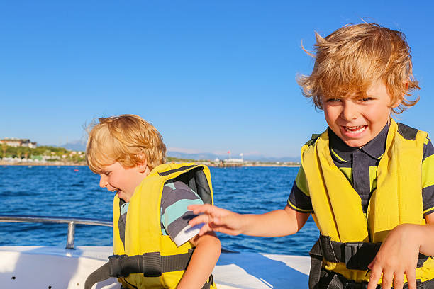 istock two little kid boys enjoying sailing boat trip 613057054