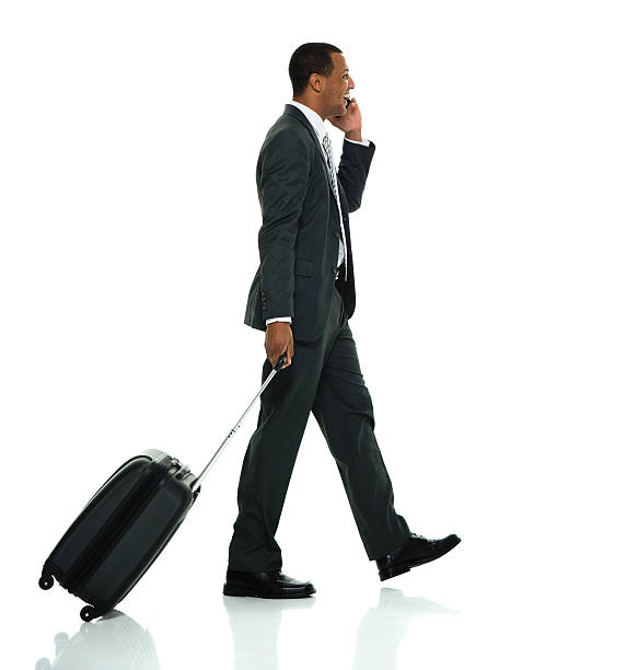 istock Smiling businessman walking and on phone 613102400