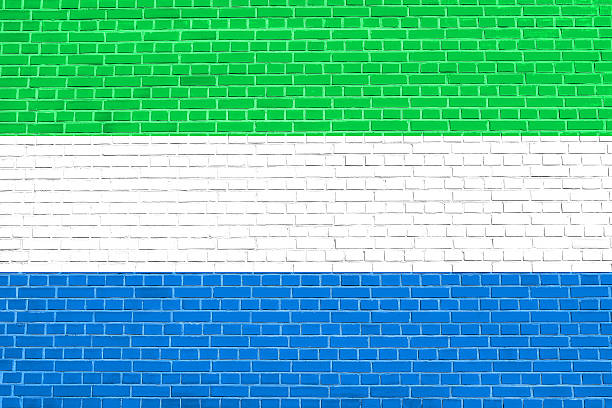Sierra Leonean national official flag. African patriotic symbol, banner, element, background. Flag of Sierra Leone on brick wall texture background