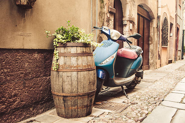 Iconic Italian scooter in a parking space designated for motorbikes. Pisa, Tuscany, Italy. Focus on the scooter. Slight toning applied.