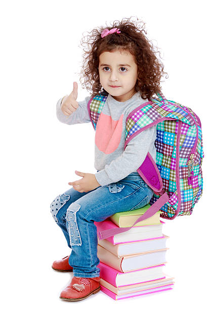 istock Little girl sitting on stack of books 613109464