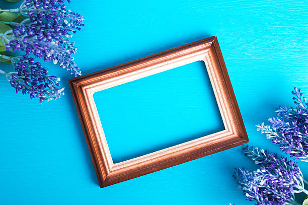 istock Wooden photo frame and lavender twig on a blue background 613109880