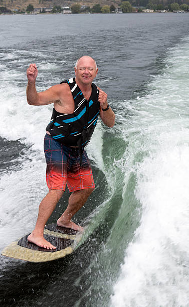 istock Baby boomer wakesurfing, wakeboarding, vertical 613112752