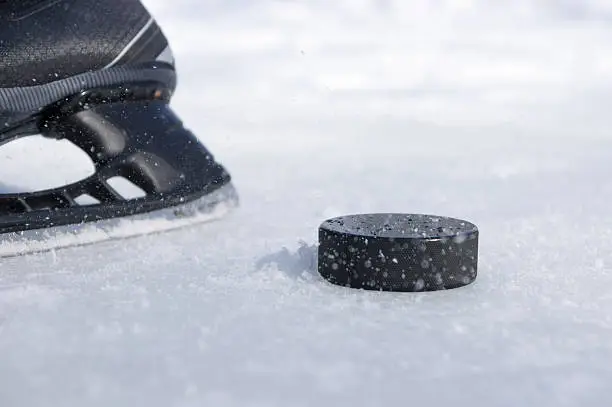 Photo of hockey skate and puck