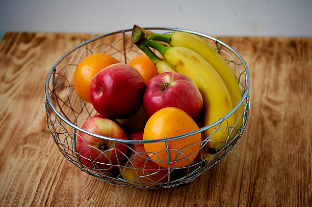 istock Metal fruit bowl on a wooden surface. Close. Bananas, oranges 613114486