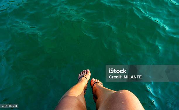 Woman Leg Sitting Over The Sea Stock Photo - Download Image Now - Adult, Bay of Water, Beach