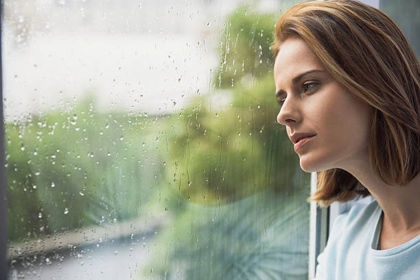 istock lonely girl looking at rain 613117876