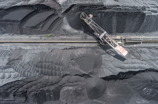 Mining excavator on the bottom surface mine. Brown coal deposits. View from above.