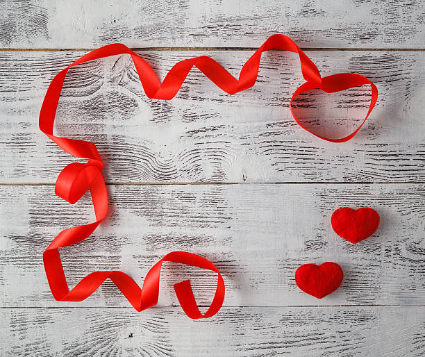 istock wooden background with red ribbon and candy hearts 613120440