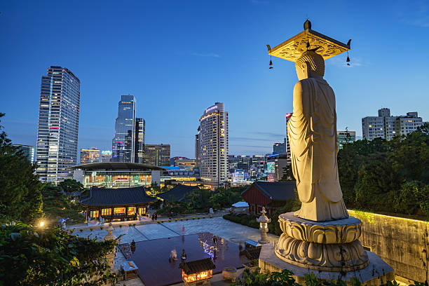 Bongeunsa Temple Seoul Modern Buildings at Night South Korea Famous Bongeunsa Temple Buddha Statue at Night - Twilight. Modern Skyscrspers of downtoen Seoul illuminated in the background. Half aerial view from the jungle behind the temple. aerial view of seoul south korea capital city stock pictures, royalty-free photos & images