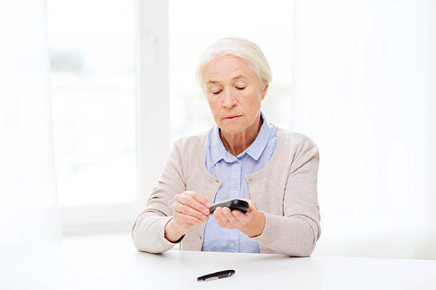 istock senior woman with glucometer checking blood sugar 613126282