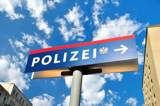 Austrian Police (Polizei) Road Sign against White Fluffy Clouds, Vienna