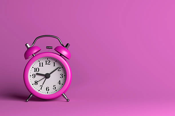 istock Purple Alarm Clock on Pink Background 613128618