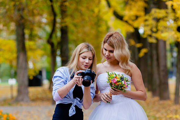 Wedding photographer discussing with the bride recently taken photos stock photo