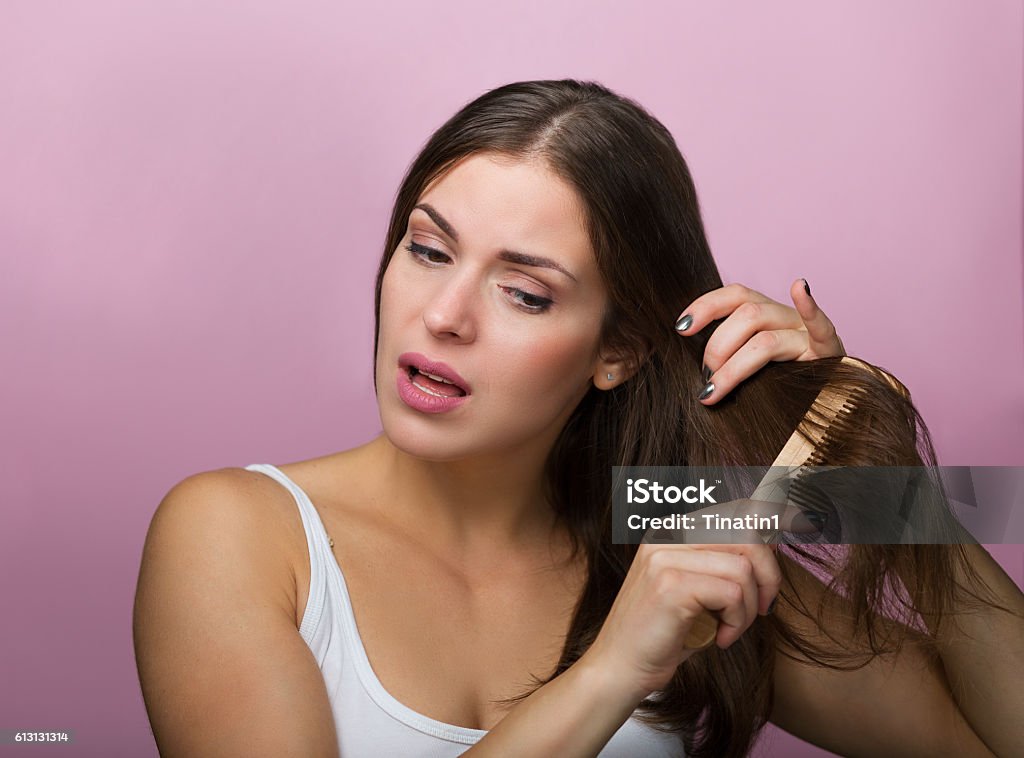 Woman brushing her hair Woman brushing her hair with a wooden comb Adult Stock Photo