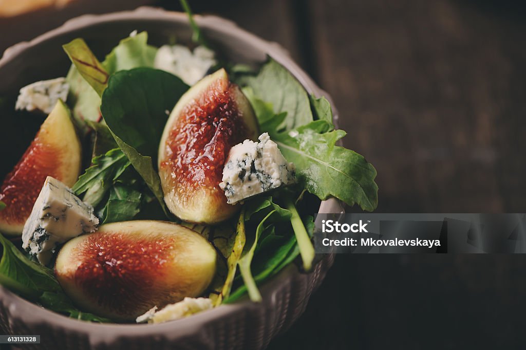 figs salad with blue cheese and ruccola on wooden background figs salad with blue cheese and ruccola on rustic wooden background. Homemade healthy food with seasonal fruitsfigs salad with blue cheese and ruccola on rustic wooden background. Homemade healthy food with seasonal fruits Blue Cheese Stock Photo