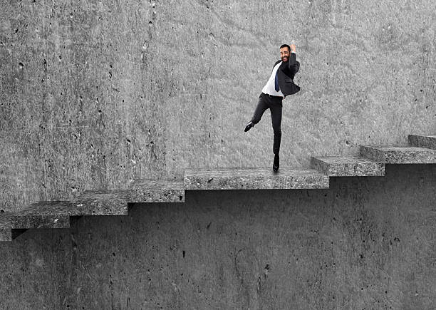 istock Excited businessman celebrating success on staircase 613131636