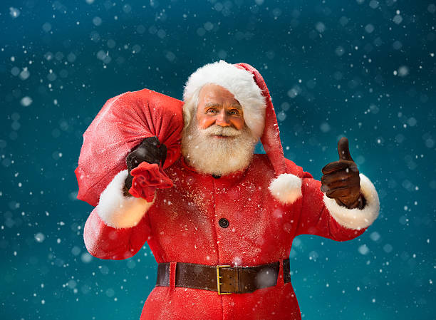 istock Happy Santa Claus gesturing thumb up with big bag 613133608