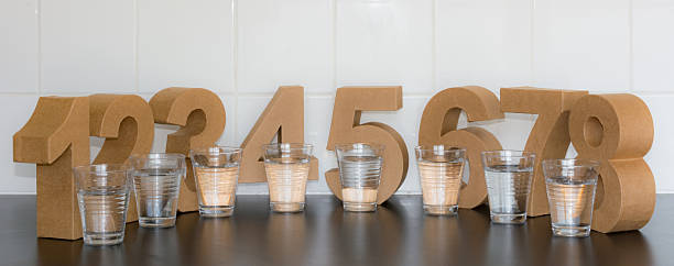 восемь стаканов воды в день - water glass glasses number 8 стоковые фото и изображения