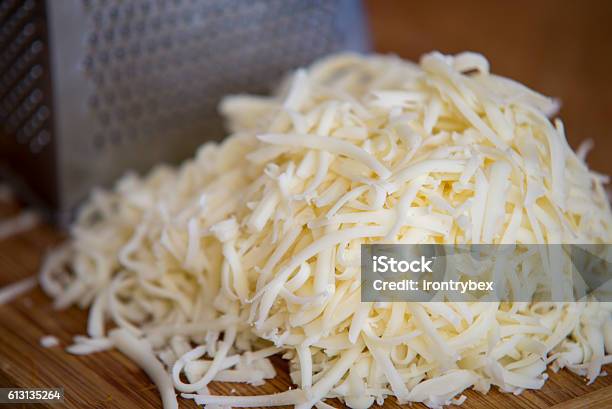 Shredded Mozzarella Cheese On A Cutting Board With A Grater Stock Photo - Download Image Now