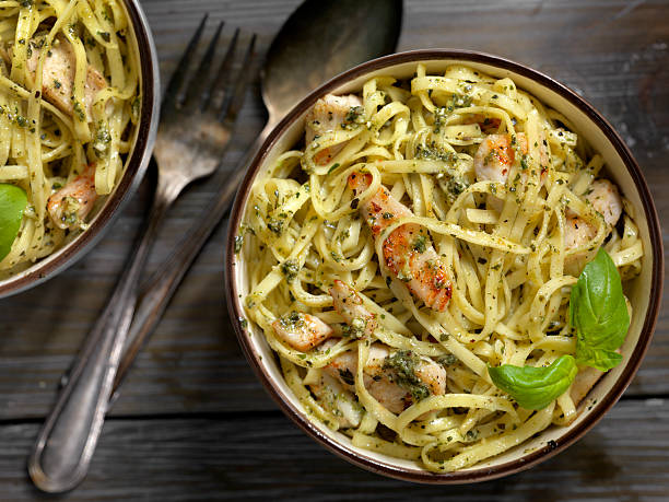 linguine mit gegrilltem huhn und basilikum pesto sauce - linguini stock-fotos und bilder