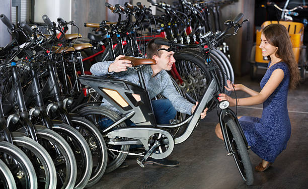 istock Couple selecting bikes at rental agency 613137686