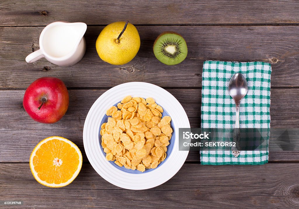 Breakfast: flakes in a plate, milk in a jug Breakfast: flakes in a plate, milk in a jug on a table, top view Apple - Fruit Stock Photo