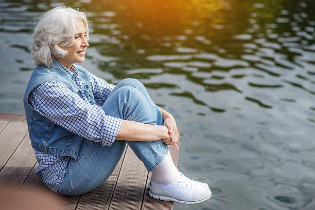 istock Dreamful old lady resting near water 613141826