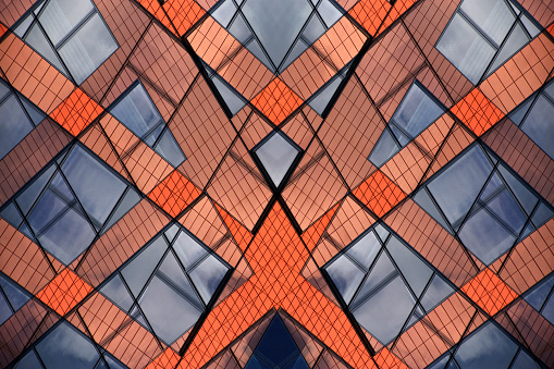 Modular structure of modern office or industrial buildings. Double exposure photo of abstract architectural pattern in vivid colors formed this symmetrical mosaic-like composition.
