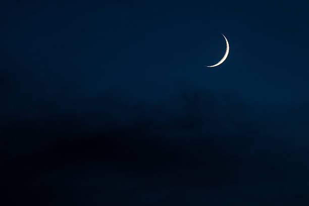 luna crescente nel cielo nuvoloso di notte - crescent foto e immagini stock