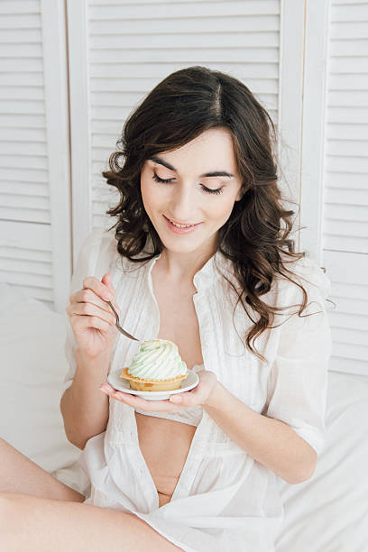 istock Girl eats cake for Breakfast in bed 613144174
