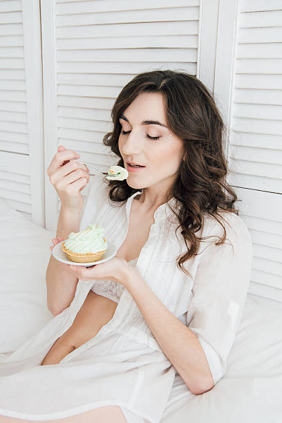 istock Girl eats cake for Breakfast in bed 613144698