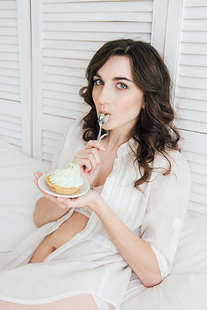 istock Girl eats cake for Breakfast in bed 613144940