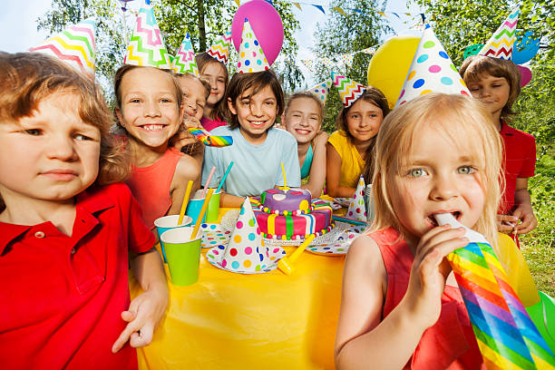 istock Happy kids having fun with party whistles 613147754