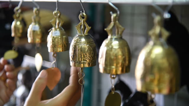 Woman tourist choosing the bells at souvenir shop in Thailand.
