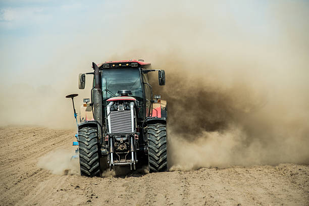 tracteur labourant les terres agricoles sèches à l’automne - photography cloud plantation plant photos et images de collection