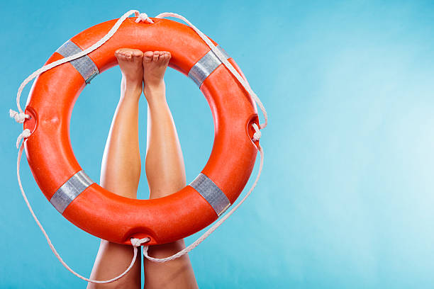 istock Life buoy ring on female legs 613210996
