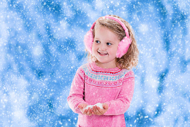 istock Little girl catching snow flakes 613212264