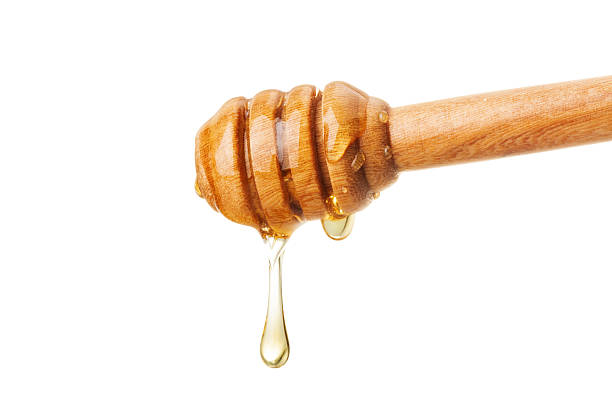 istock Honey and wood dipper isolated on white background 613214452