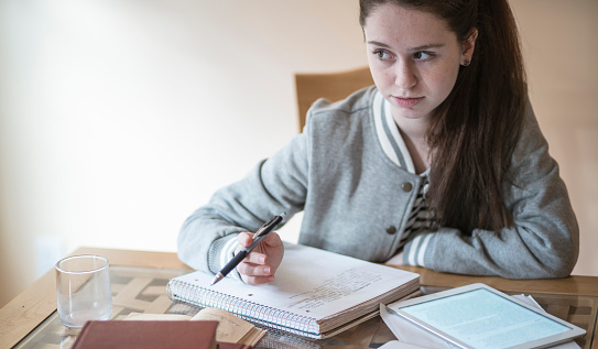 Teenager girl, 16-years-old high school student, doing the writing homework