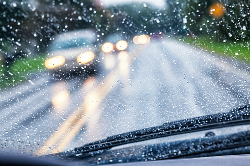 Conductor de la carretera POV a través de gota de lluvia parabrisas del coche durante la tormenta de lluvia photo