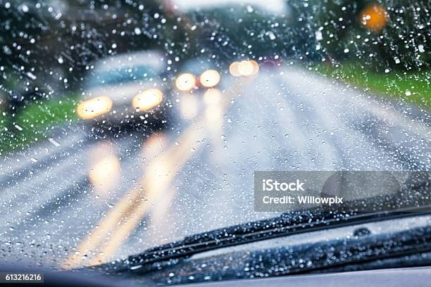 Conductor De La Carretera Pov A Través De Gota De Lluvia Parabrisas Del Coche Durante La Tormenta De Lluvia Foto de stock y más banco de imágenes de Lluvia