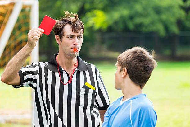 istock Referee shows red card and blows whistle during soccer game 613216592