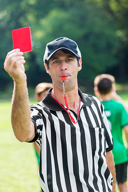 istock Soccer referee shows a red penalty card while blowing whistle 613216662