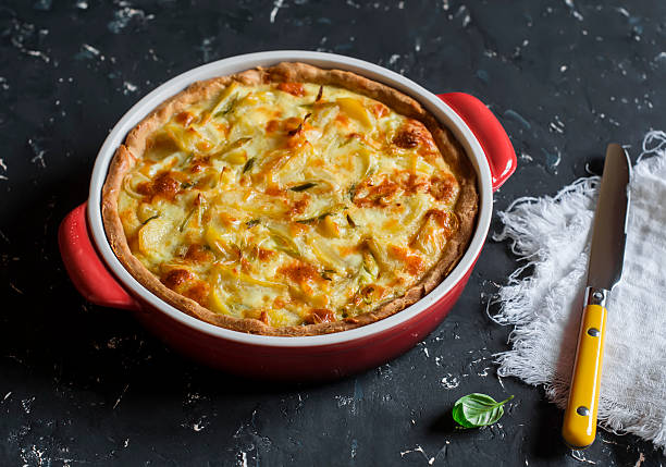 Leek, potato and cheese pie in baking dish Leek, potato and cheese pie in baking dish on a dark background. pepper cake stock pictures, royalty-free photos & images
