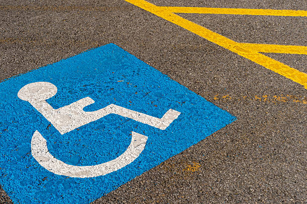 disabled blue parking sign painted on dark asphalt in Canada stock photo