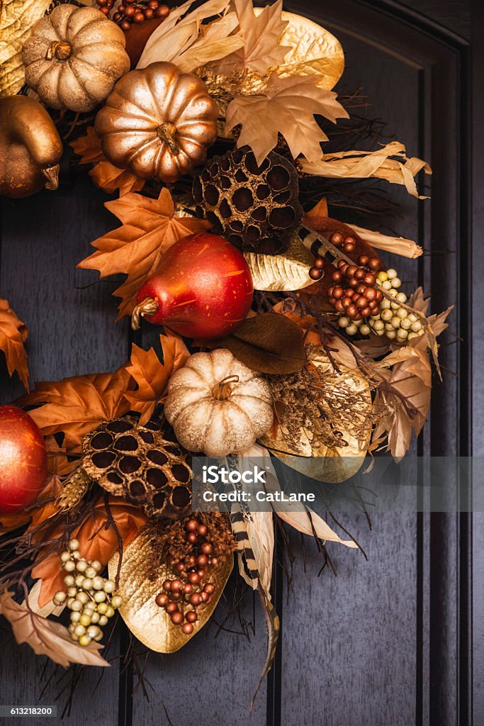 Ornate fall wreath with gold pumpkins hanging on front door Wreath Stock Photo